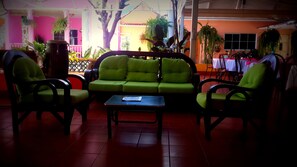 A seating area with a green sofa and chairs, a small table, and potted plants. - Hotel San Jerónimo (San Jeronimo)