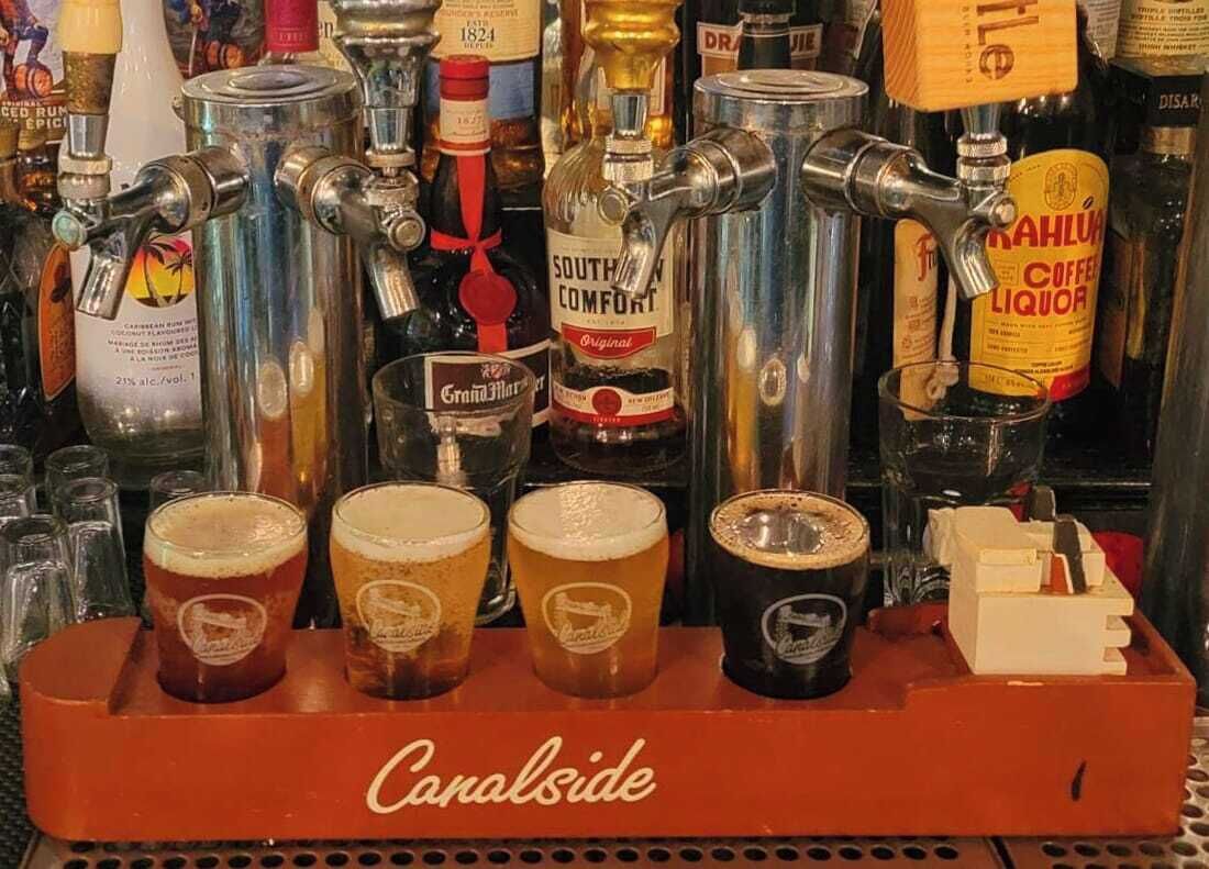 A bar area with multiple taps dispensing various beverages, including a prominently displayed bottle of South Comfort Liquor.