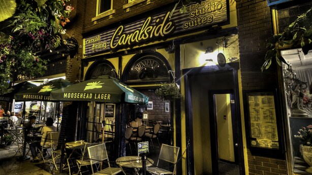 Un pub llamado Canalside con terraza y un anuncio de cerveza Moosehead Lager.