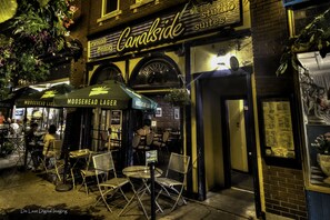 Un pub llamado Canalside con terraza y un anuncio de cerveza Moosehead Lager.