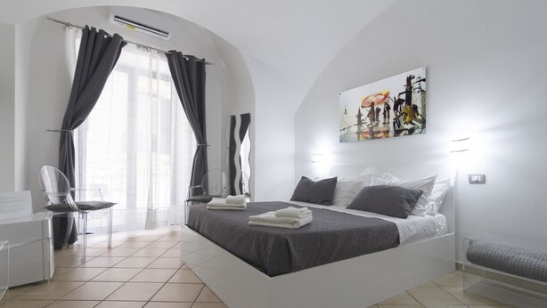 Une chambre d’hôtel moderne avec un grand lit, un bureau et une chaise.