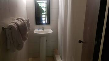 Ein Badezimmer mit Waschbecken, Spiegel und Handtuchhalter mit Handtüchern.
