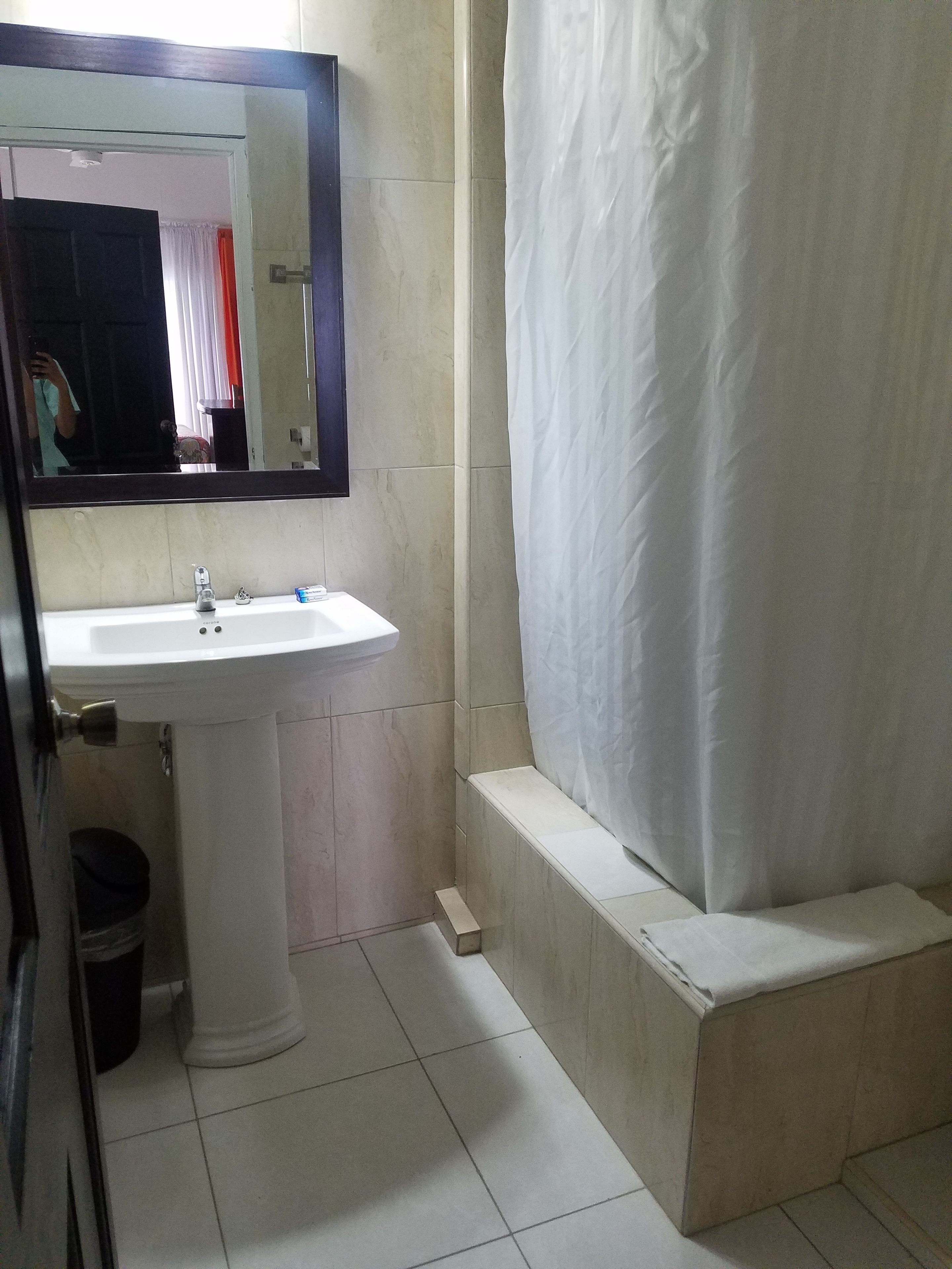 A bathroom with a white sink, a mirror, and a shower curtain.