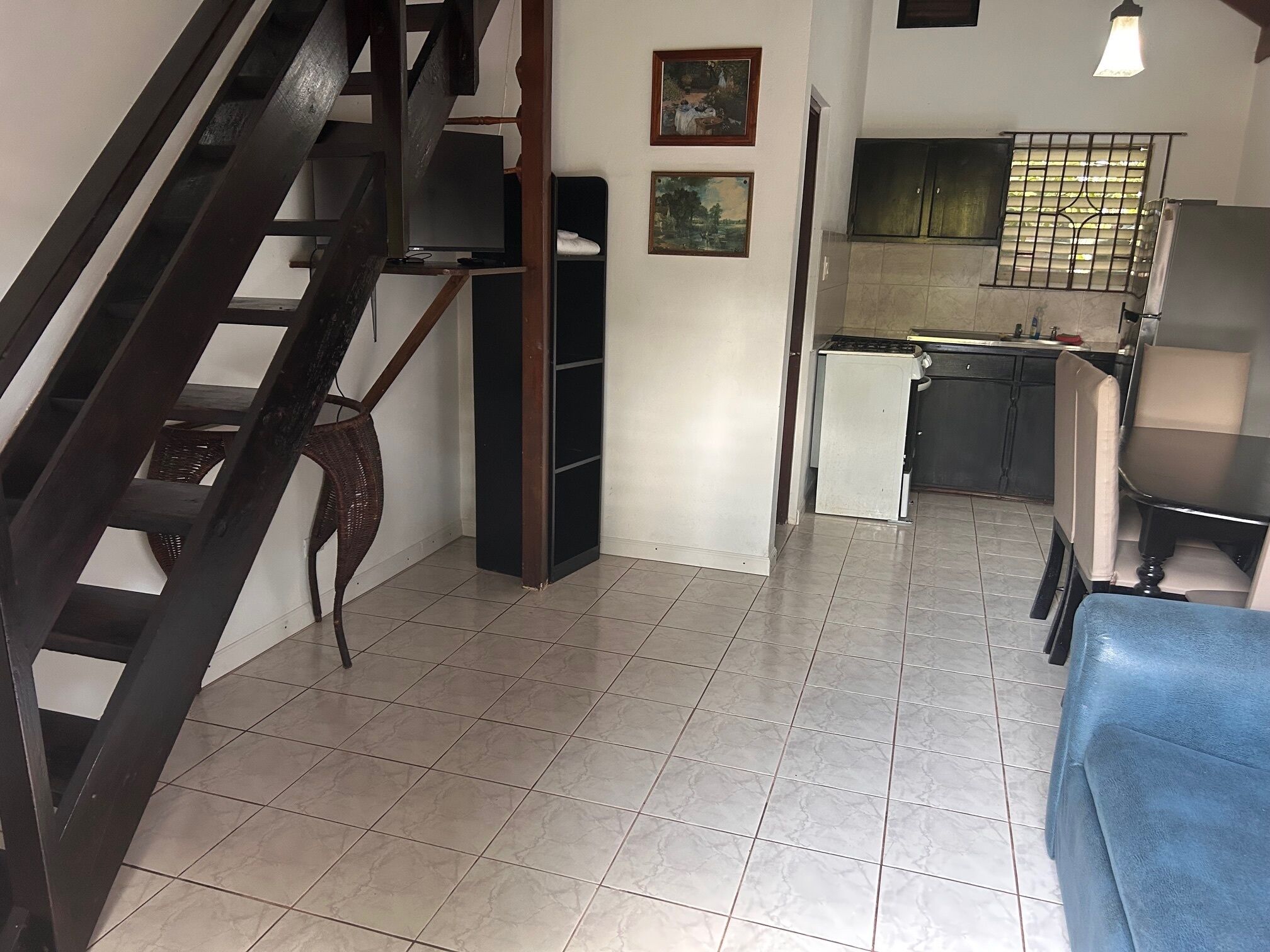 A staircase leading to a living area with a kitchen and dining area.