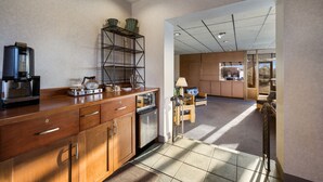 A modern kitchen with a coffee machine, a dishwasher, and a metal shelf with kitchenware. - Gateway Inn (Merrick)