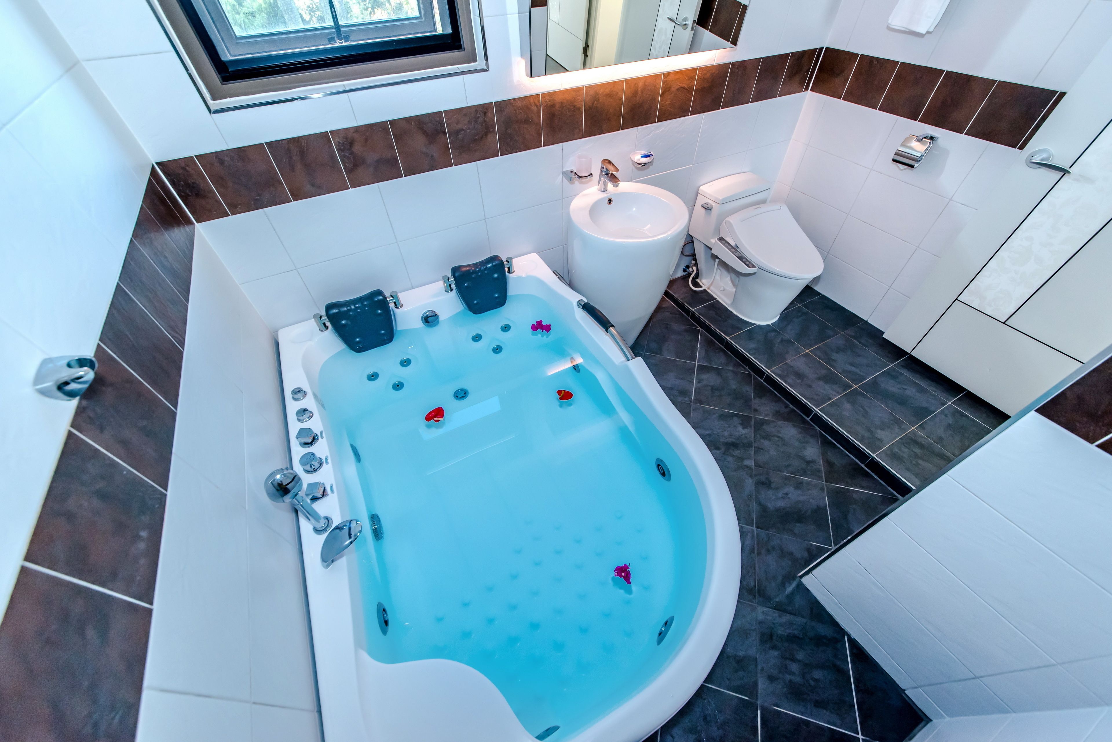 A modern bathroom with a large bathtub, a sink, and a toilet.