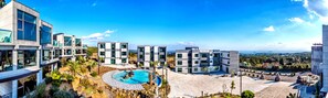 Un hotel moderno con piscina, varias edificaciones y vistas del paisaje circundante.