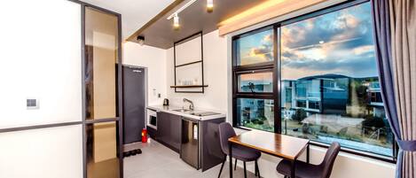 A modern kitchen with a sink, a small island, and a window with a view of buildings.