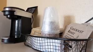 A coffee maker, a plastic container, and a bag labeled "Gourmet Roast" on a countertop. - Galaxie Motel (Philomath)
