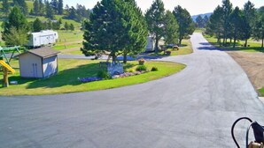 A residential street with houses, a playground, and a small shed. - Rush No More RV Resort and Cabins - Campground (Sturgis)