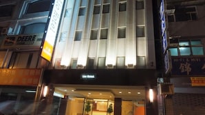 A hotel with a modern facade, illuminated signage, and a visible entrance. - Lio Hotel (Taipei)