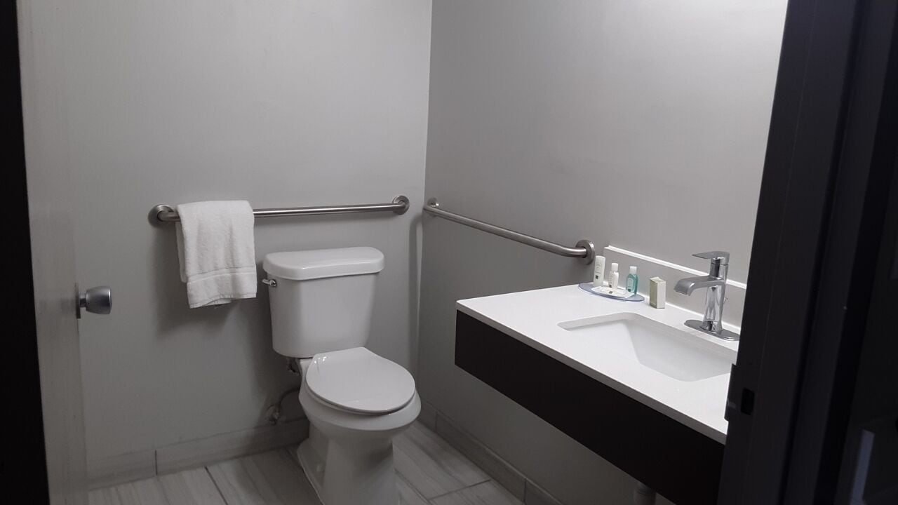 Moderni kylpyhuone, jossa on wc, pesuallas ja pyyheteline.