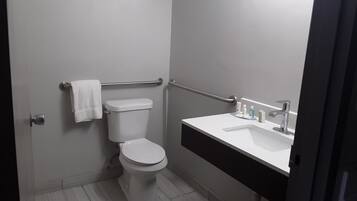 Moderni kylpyhuone, jossa on wc, pesuallas ja pyyheteline.