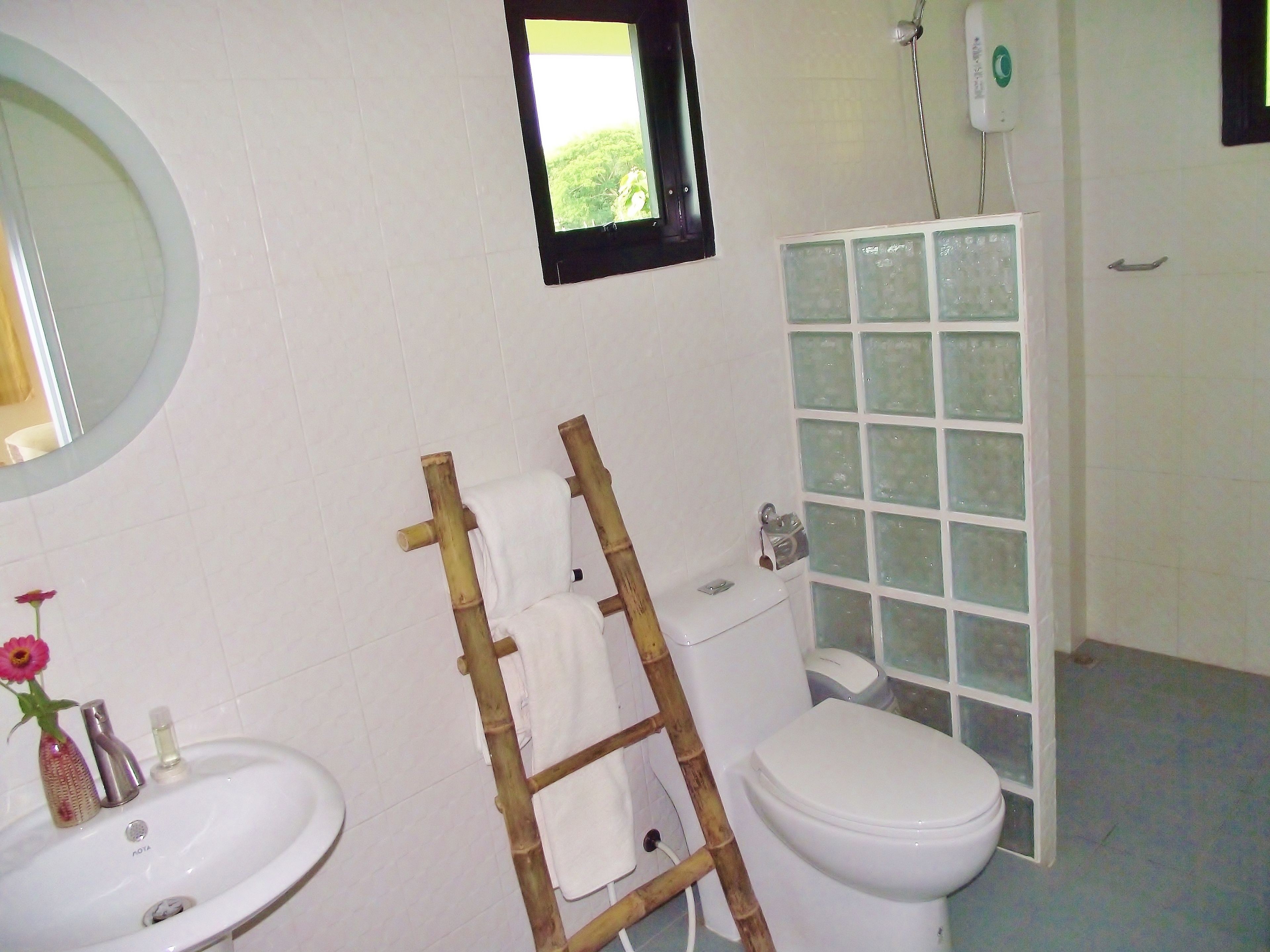 A bathroom with a white sink, toilet, and a shower area with frosted glass doors.