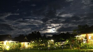 A nighttime view of a resort with illuminated buildings and a visible moon. - Country Retreat (Mae Rim)
