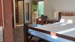 A bedroom with a wooden bed, a nightstand with a lamp, a chair, and a wardrobe. - Country Retreat (Mae Rim)