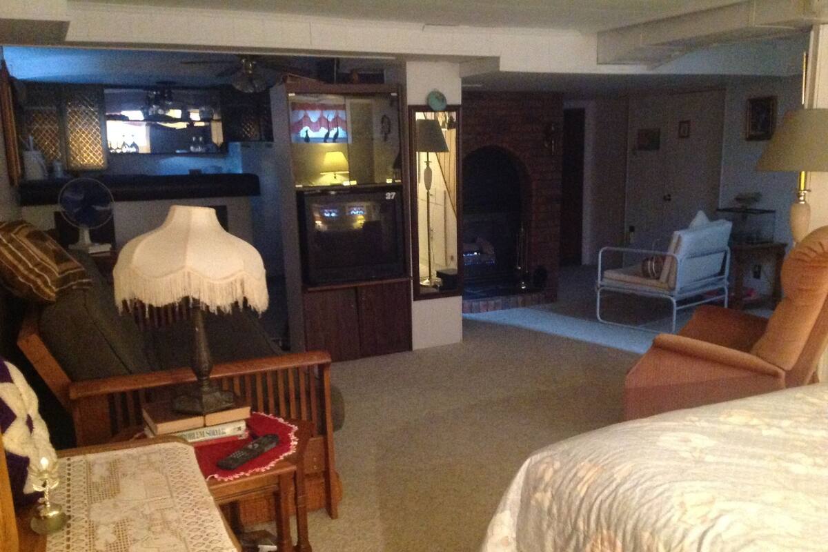 Una sala de estar con chimenea, televisor y comedor con mesa y sillas.