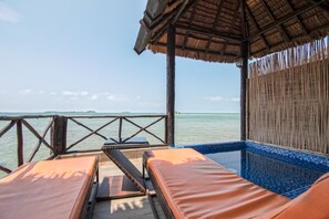 A beachside lounge with a view of the sea, a thatched roof, and a small pool area. - Bintan SpaVilla Beach Resort (Bintan)
