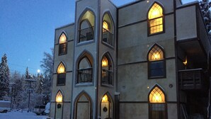 A multi-story building with arched windows and balconies, surrounded by snow. - Fairbanks Extended Stay (Fairbanks)