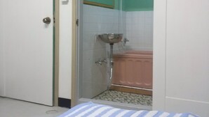 Et badeværelse med brusebad, vask og toilet.