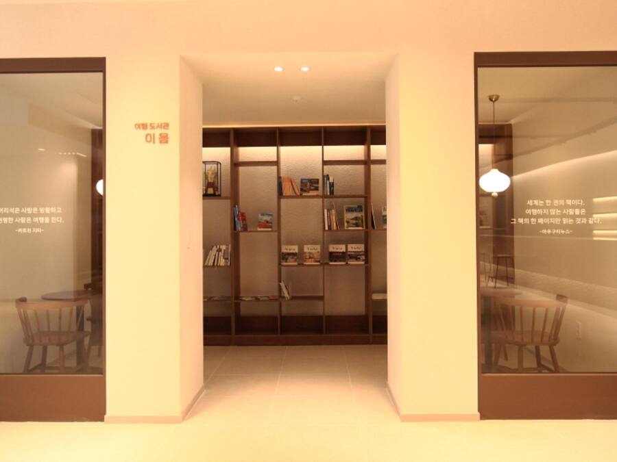 A modern interior with a central bookshelf, two glass doors, and a ceiling light.