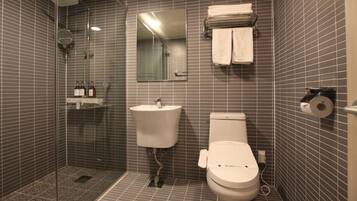 A bathroom with a shower, sink, toilet, and a towel rack.