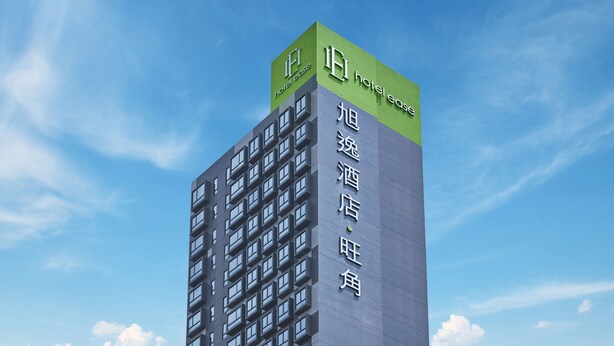 Een hoog hotelgebouw met meerdere verdiepingen en een groen bord aan de bovenkant.