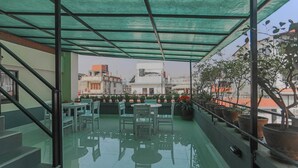 A covered outdoor area with a glass floor, a staircase, and potted plants. - Fuji Hotel (Kathmandu)