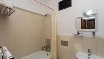 A bathroom with a bathtub, a sink, and a mirror.