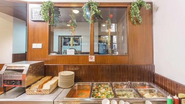 A buffet with various food options and utensils. - Fuji Hotel (Kathmandu)