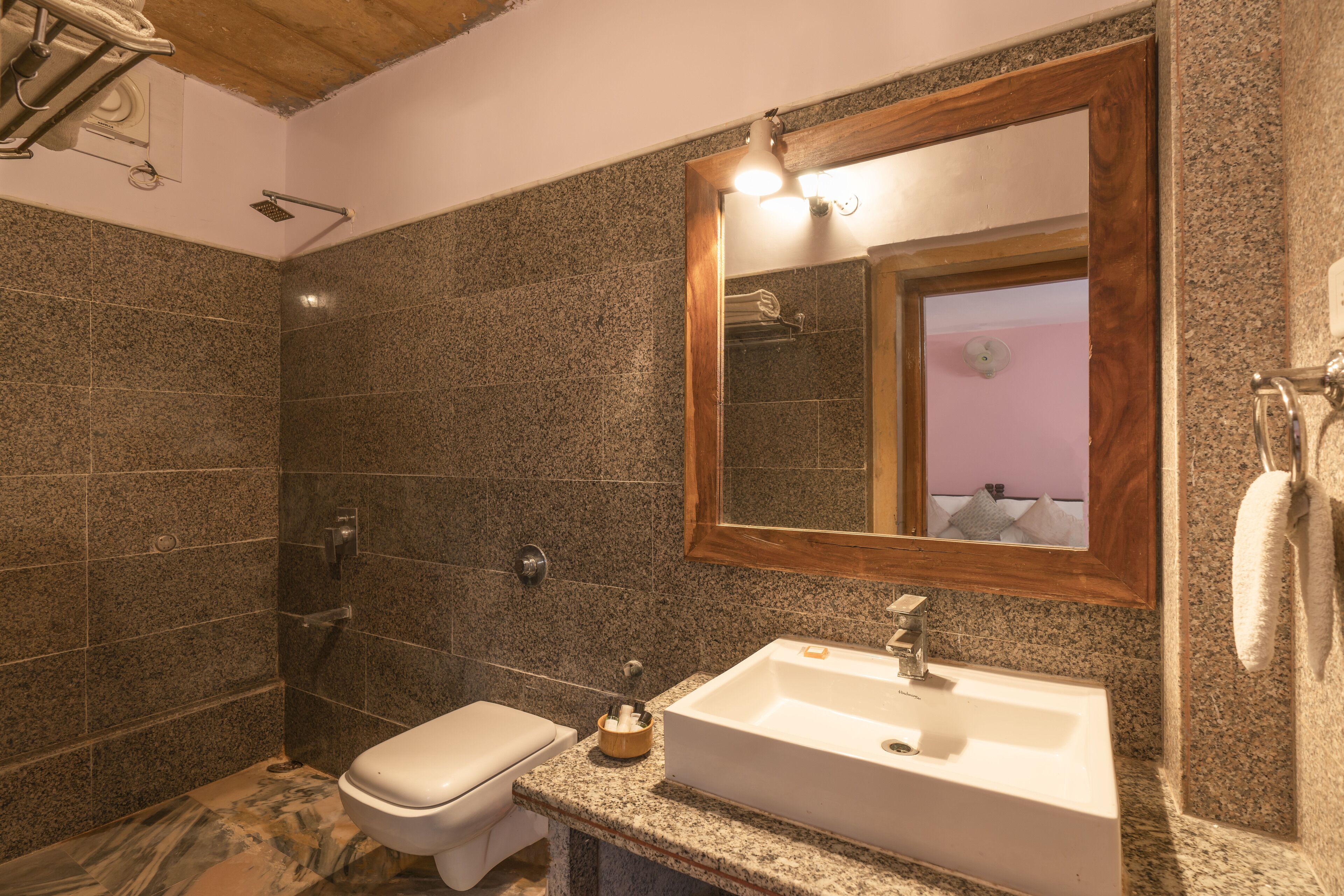 A bathroom with a white sink, a mirror, and a shower.