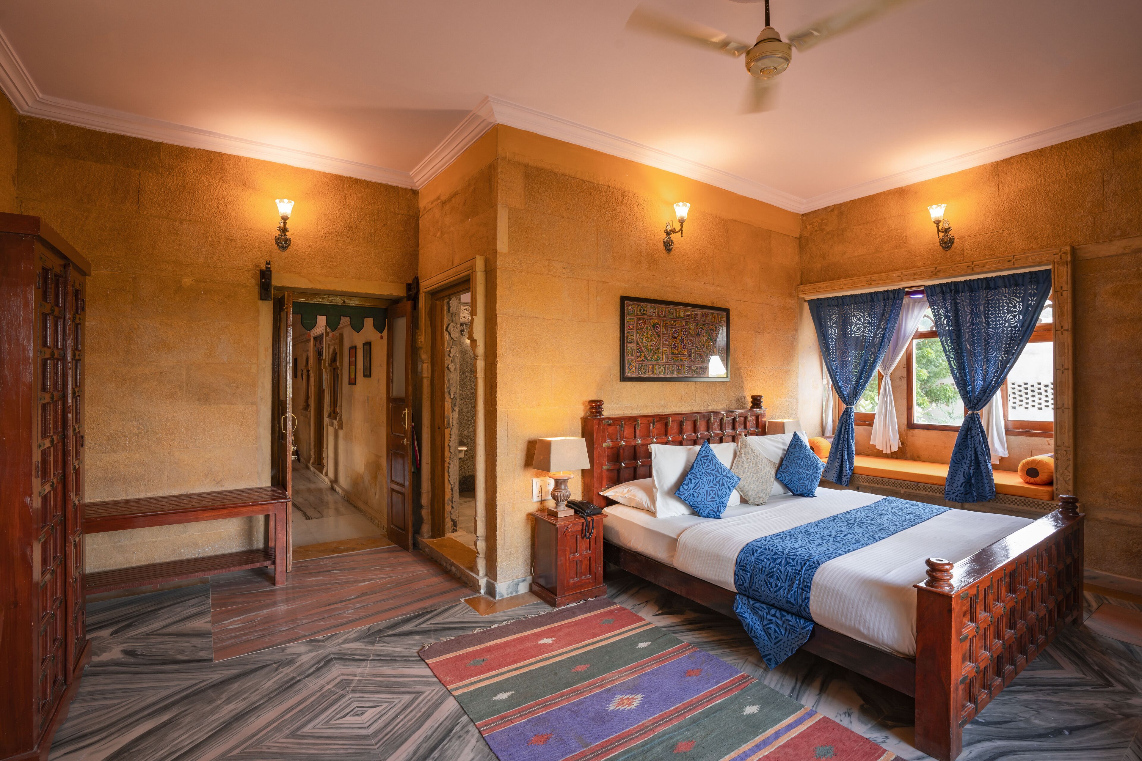A traditional room with a bed, wooden headboard, and a bench.