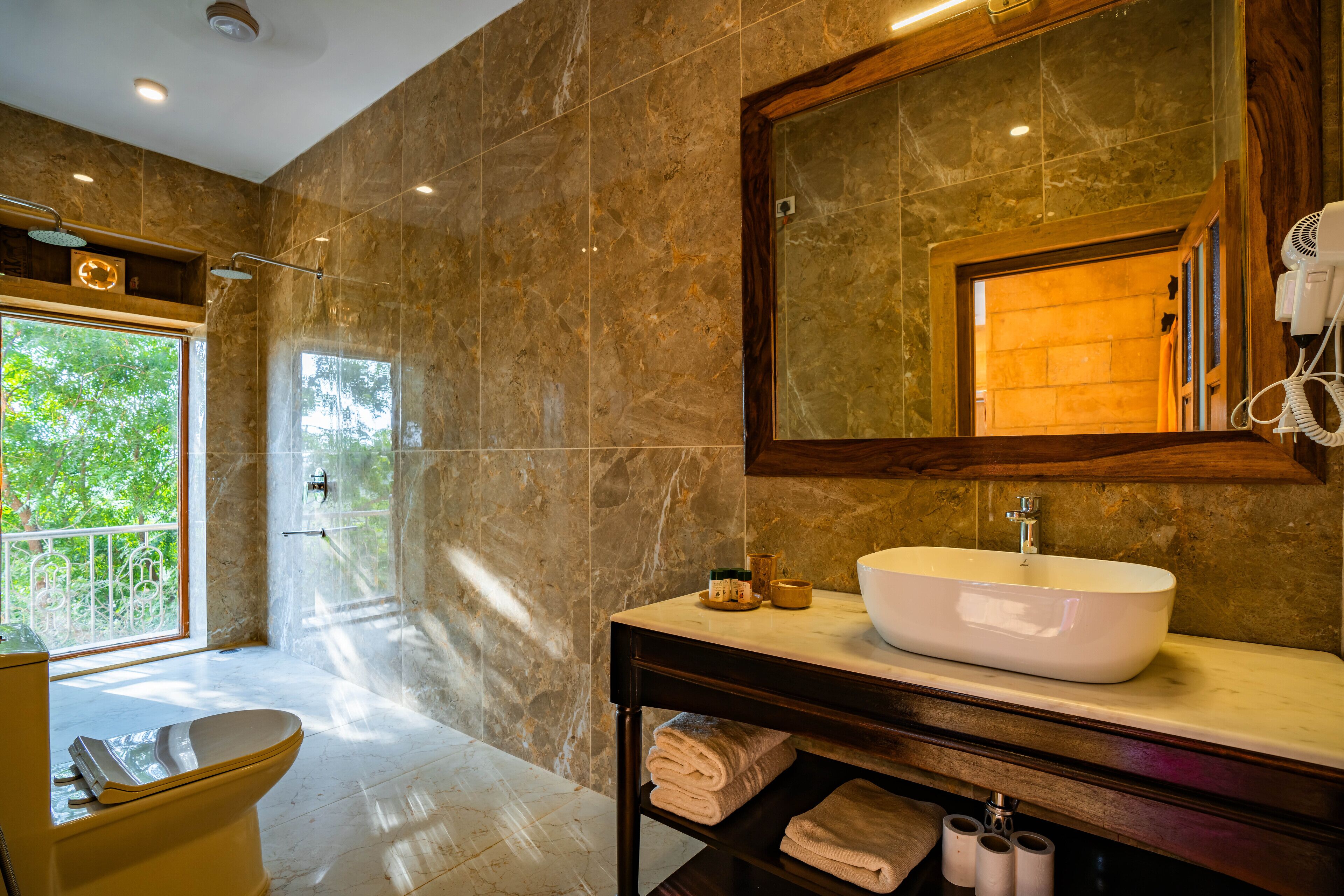 Un bagno moderno con uno specchio grande, un lavabo a incasso e un water.