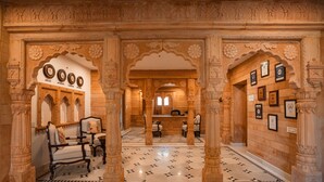 Un vestíbulo con arcos decorativos, una recepción y relojes que marcan diferentes ciudades.