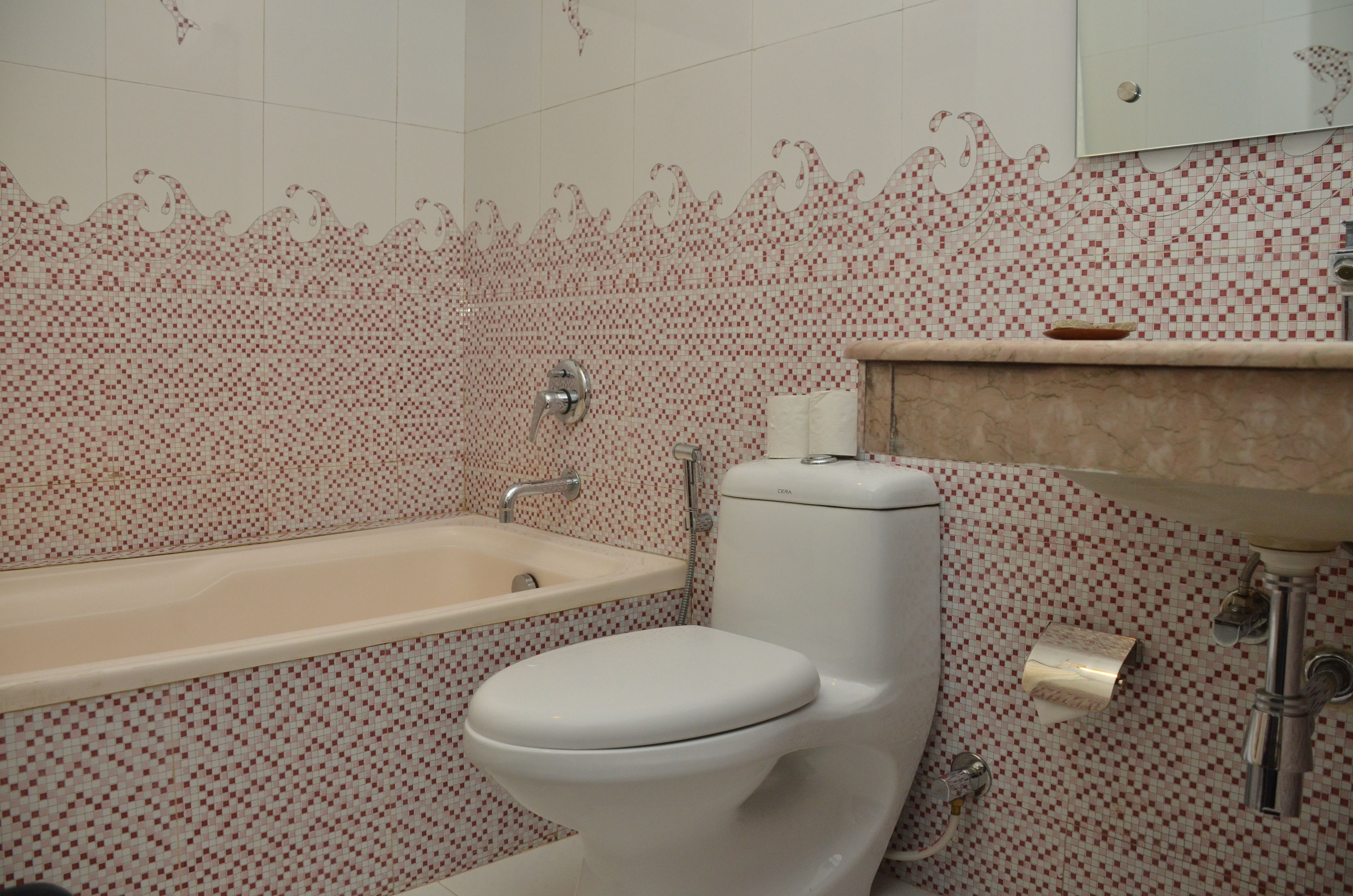A bathroom with a toilet, bathtub, and sink.