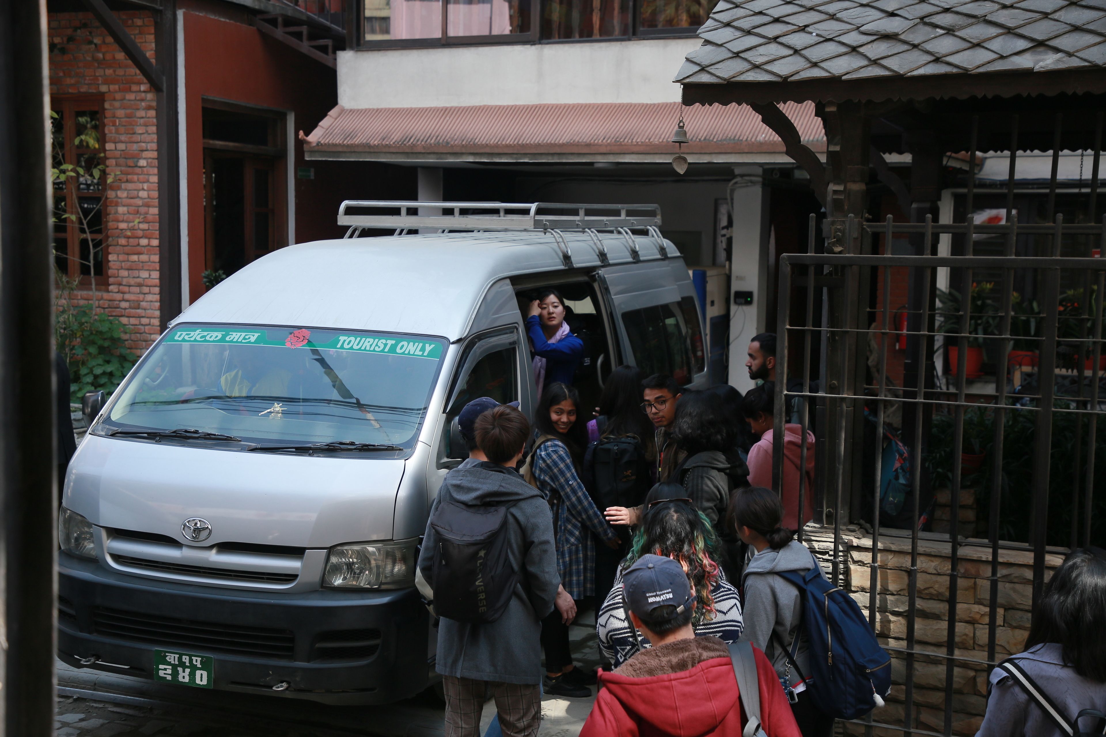 A group of people boarding a van with a sign indicating it is for tourists only.