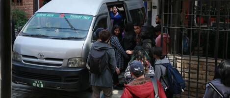 A group of people boarding a van with a sign indicating it is for tourists only.