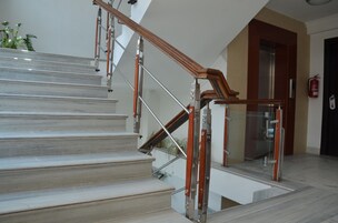 Una escalera con barandillas de madera y de vidrio que conduce a un piso superior.