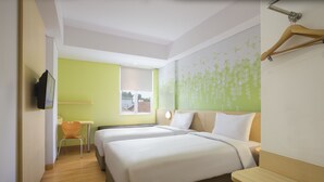 A hotel room with two beds, a desk, and a chair. - Zest Bogor by Swiss-Belhotel International (Bogor)