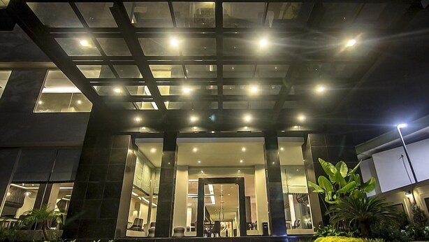 Un edificio moderno con fachada de vidrio, ventanas amplias y una zona de entrada bien iluminada.