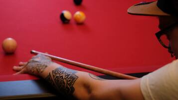 A pool table with balls and a pool cue.