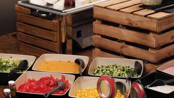 A buffet table with various food items and condiments.
