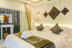 A hotel room with a bed, a bathroom, and a wall-mounted air conditioner. - Sahaa Beach Resort (Sihanoukville)