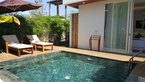 A pool area with two lounge chairs, a wooden deck, and a glass door leading to a bedroom. - Sahaa Beach Resort (Sihanoukville)
