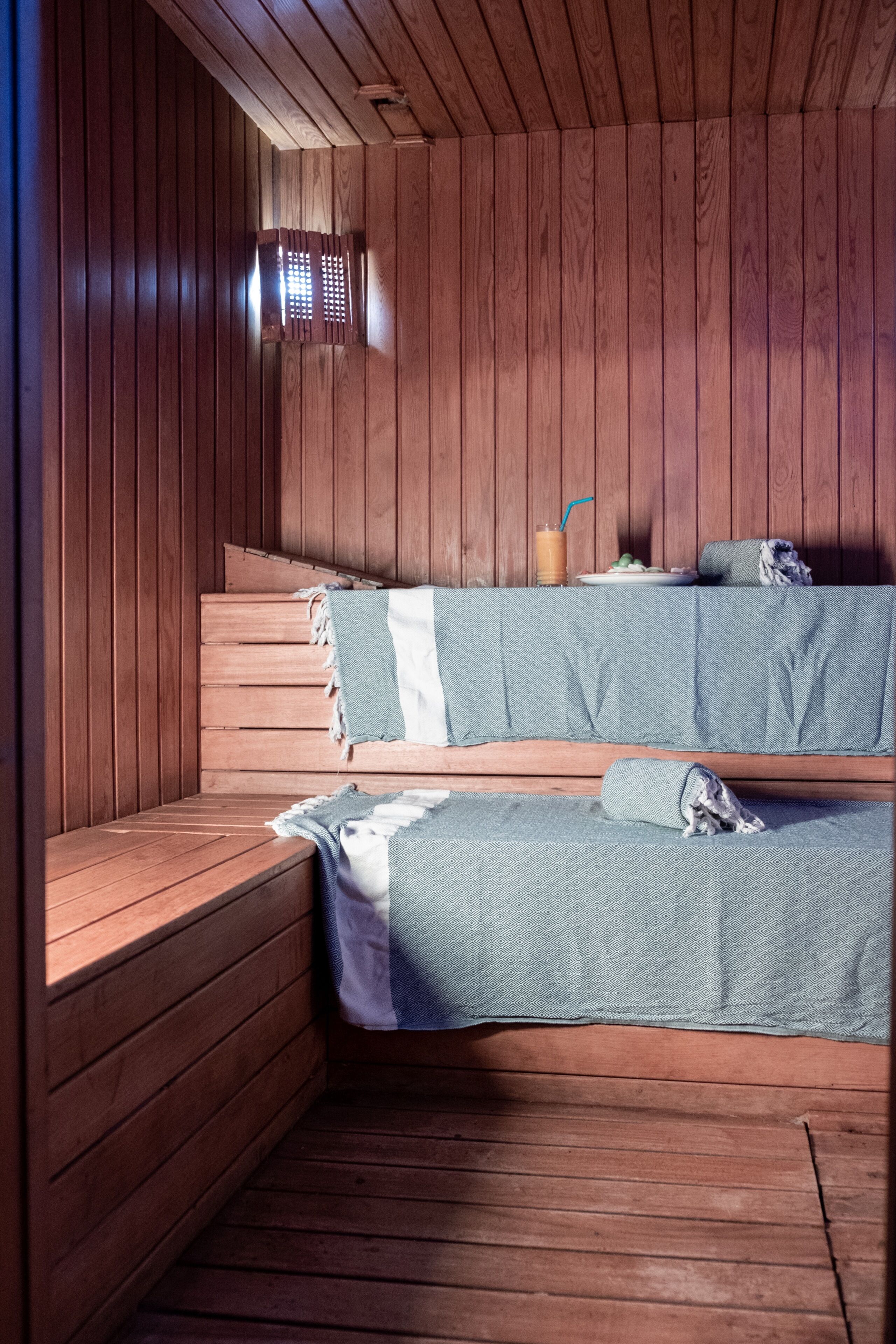 Una sauna con bancos de madera y bancos cubiertos con toallas.