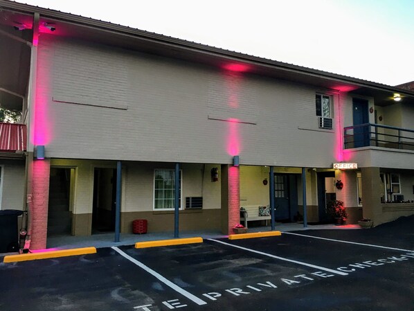 A building with a sign reading "OFFICE" and a parking lot with "PRIVATE CHECK-IN" marked.