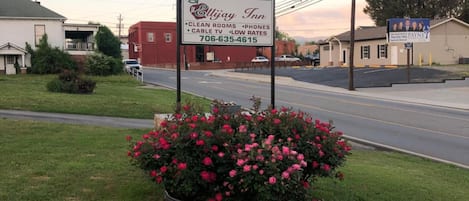 A roadside sign for Ellijay Inn, highlighting amenities like clean rooms, phones, cable TV, and low rates.