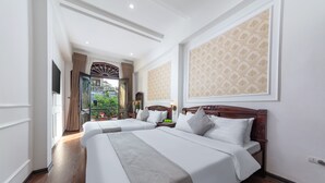 Une chambre d’hôtel avec deux lits, une grande fenêtre et un balcon avec vue.