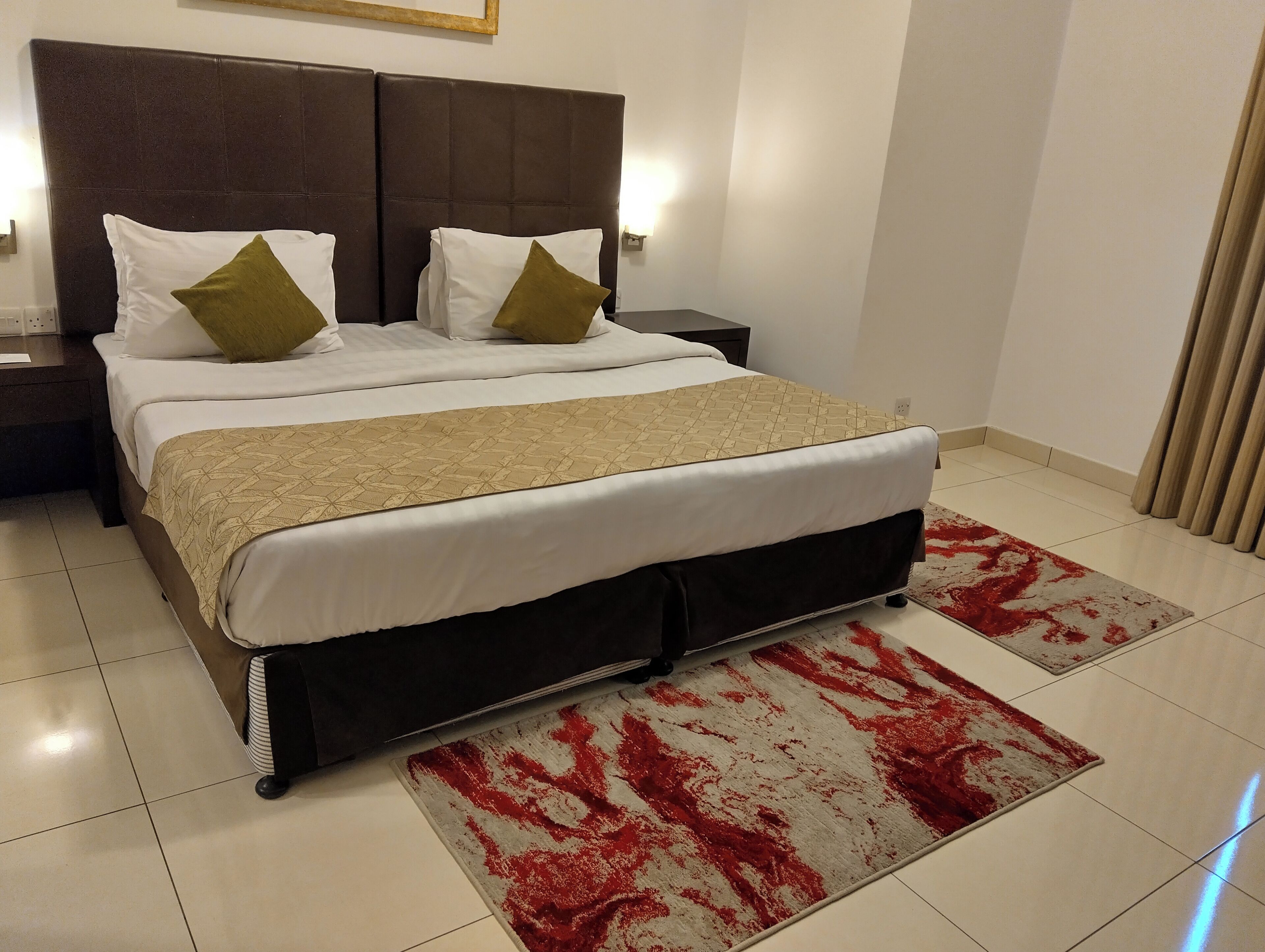 A neatly made bed with a patterned bedspread, two pillows, and a headboard.