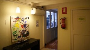 A hallway with a fire extinguisher, a sign labeled "Japan," and a door. - Palace Guesthouse (Barcelona)
